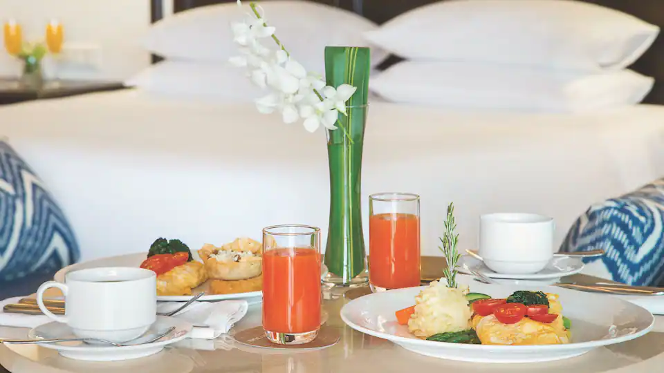 In-room dining service at Hyatt Zilara Cap Cana featuring a gourmet breakfast spread, fresh fruit, pastries, and elegant guest room setting.