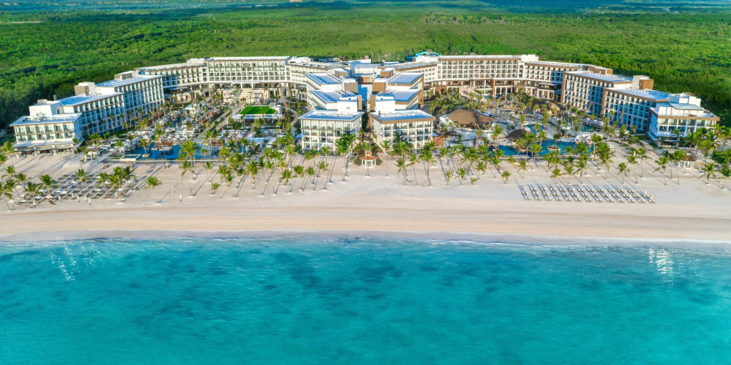 Aerial view of Hyatt Zilara Cap Cana beachfront resort with pools, palm trees, and turquoise Caribbean waters.
