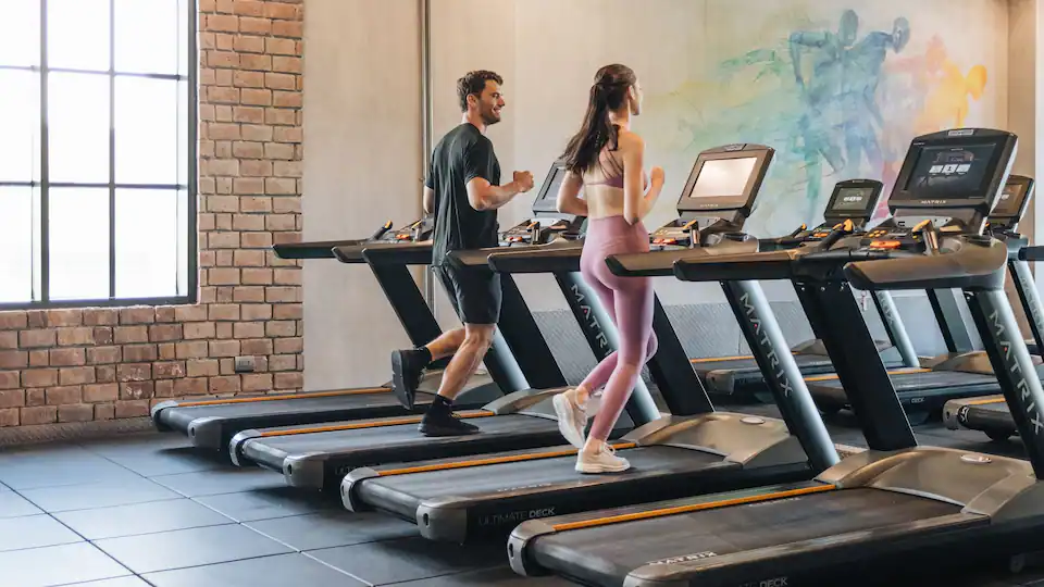 Guests exercising on treadmills inside The Refinery Fitness Center at Hyatt Zilara Cap Cana.
