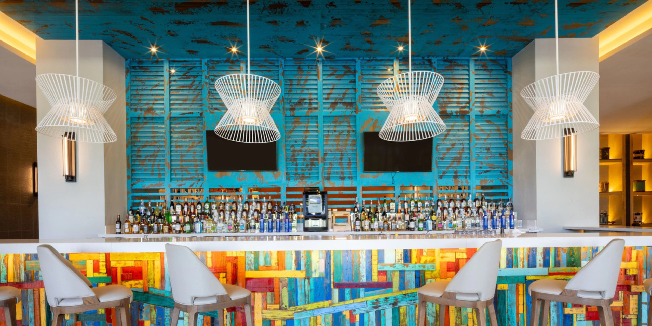 Stylish lobby bar with colorful décor and premium spirits at Hyatt Zilara Cap Cana, an adults-only luxury all-inclusive resort in Punta Cana.