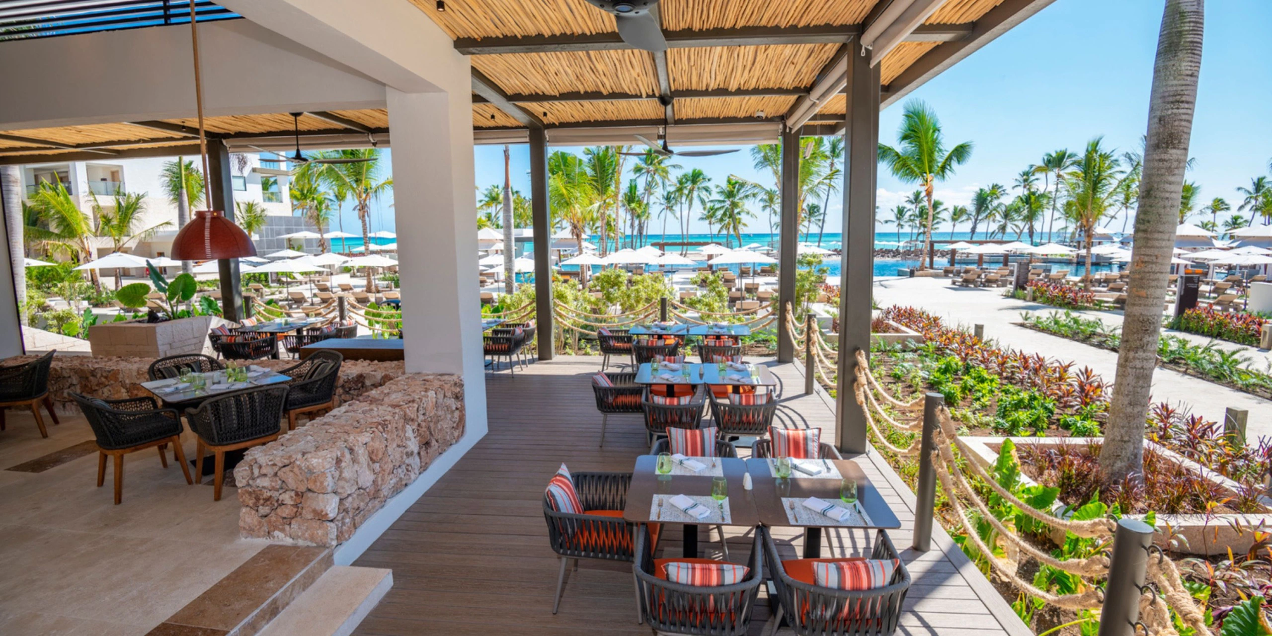 Open-air restaurant terrace overlooking pools and tropical gardens at Hyatt Zilara Cap Cana.