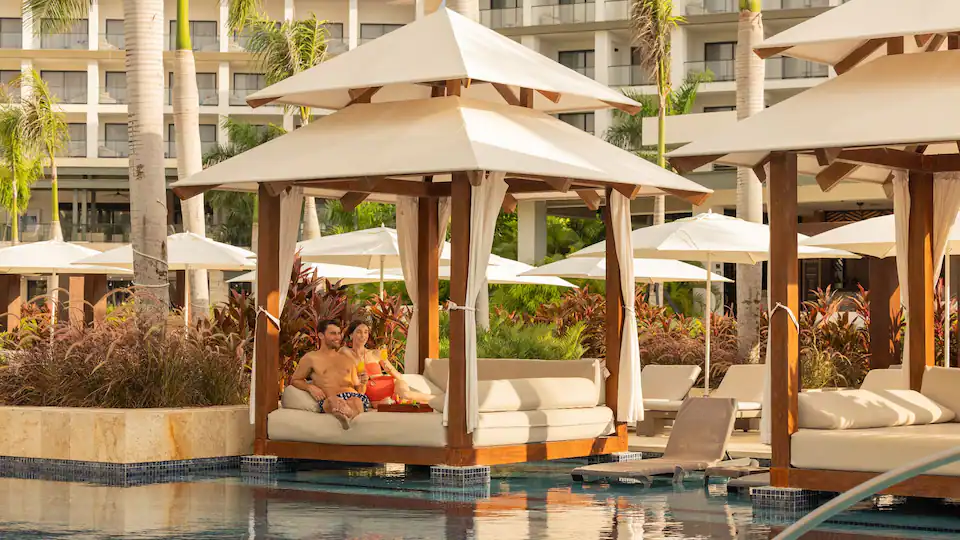 Couple relaxing in a luxury poolside cabana at Hyatt Zilara Cap Cana in Punta Cana.