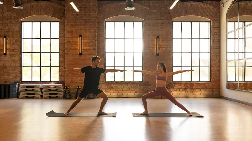 Couple practicing yoga in a modern fitness studio at Hyatt Zilara Cap Cana, offering wellness and fitness experiences for adults-only guests.